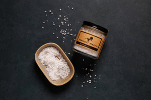 One jar of Vermont Wagyu heirloom salt next to a salt dish with salt. 