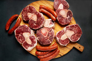 5 raw Wagyu shank bones and two packages of Wagyu Chorizo on a cutting board