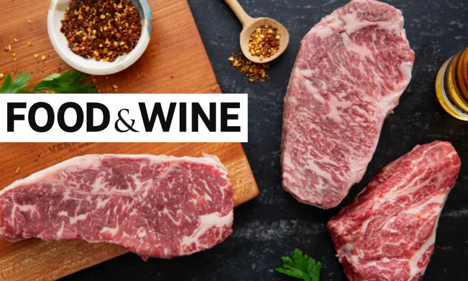 Raw steaks on a cutting board with spices and 'Food & Wine' logo.